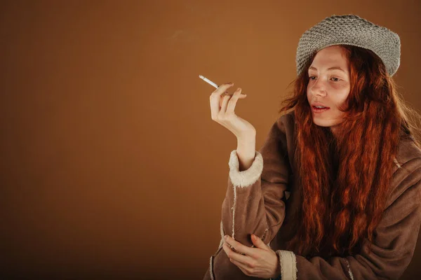 Ginger Dívka Pózuje Cigaretou Ruce Zatímco Sedí Studiu — Stock fotografie