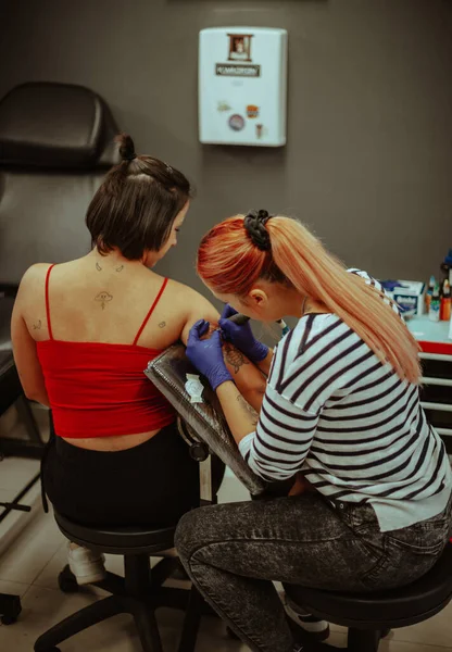 Tatuaje Artista Con Pelo Rojo Está Tatuando Cliente Mientras Está —  Fotos de Stock