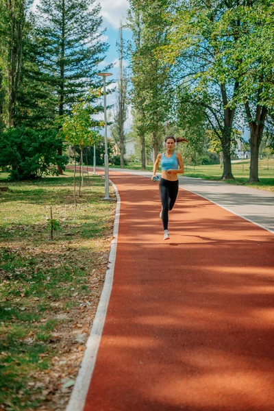 公園のスポーツコースで晴れた日にジョギングする女の子 — ストック写真