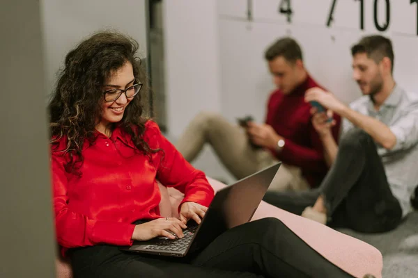 Güzel Kıvırcık Saçlı Kadını Ofisteki Kanepede Uzanıyor Laptopunda Iyi Bir — Stok fotoğraf