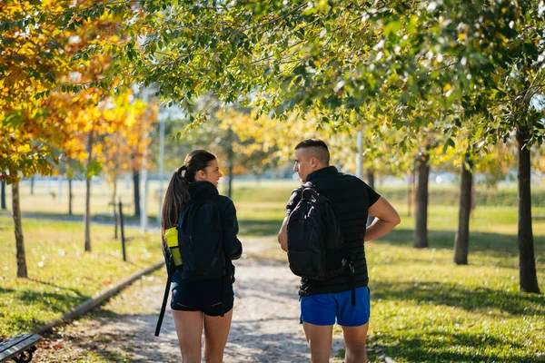 バックパックを持って歩くスポーツカップルの写真 — ストック写真