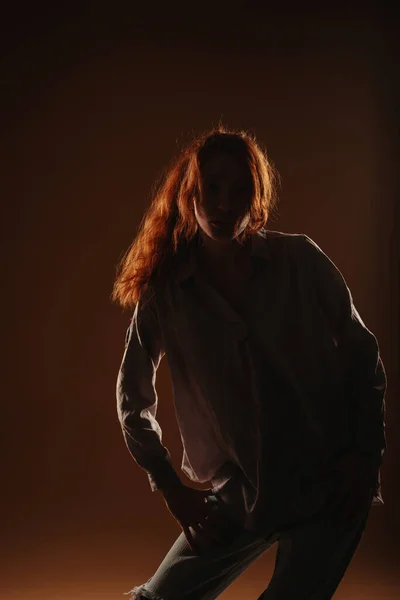 Uzun Boylu Kızıl Bir Kızın Silueti Kahverengi Bir Arka Planda — Stok fotoğraf