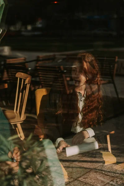 素敵なジンジャービジネスの女の子がコーヒーバーでリモートで働いています 正面の写真 窓からの写真 — ストック写真