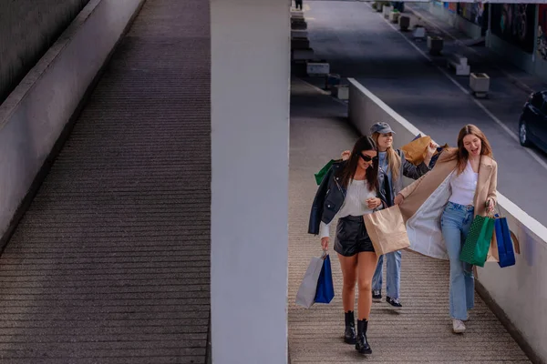 20多岁的女孩在外面散步 玩得很开心 他们手里拿着很多购物袋 — 图库照片