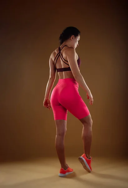 Sexy Vrouw Roze Shorts Bordeaux Sportshirt Poserend Studio Achteraanzicht Foto — Stockfoto