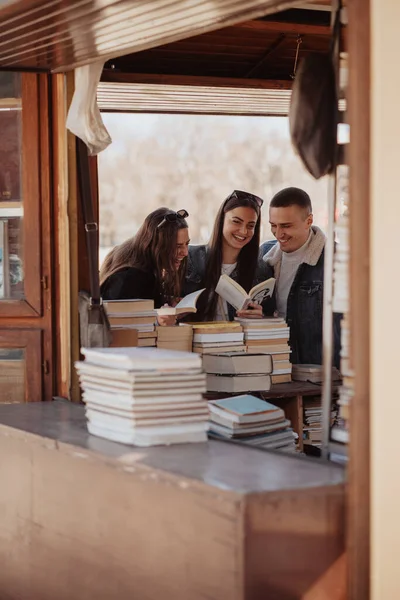 Tres Amigos Cercanos Riéndose Pie Librería Sosteniendo Libros —  Fotos de Stock