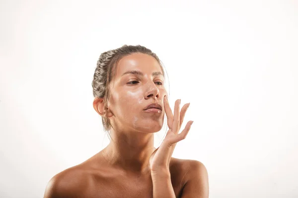 Primer Plano Chica Untando Crema Facial Sus Mejillas Estudio Fondo — Foto de Stock