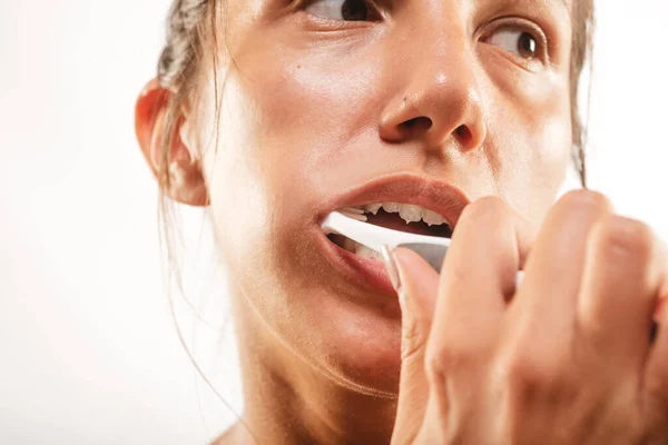 Stüdyoda Dişlerini Fırçalayan Esmer Bir Kızın Beyaz Bir Arka Planı — Stok fotoğraf