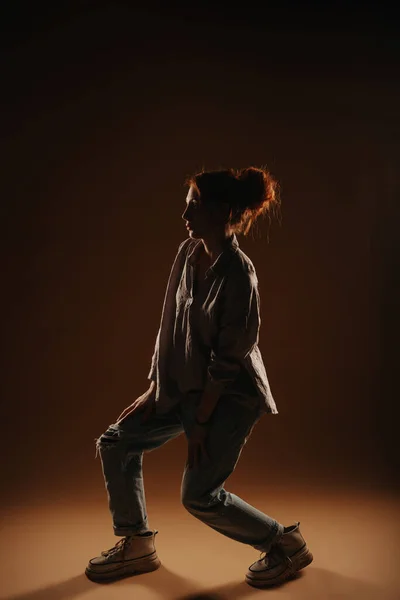 Stock image Beautiful silhouette of a ginger girl posing while standing at the studio