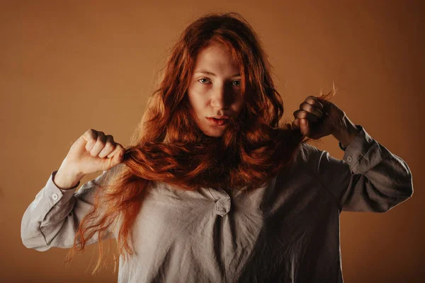 閉じるアップの美しいです赤い毛の女の子Posing彼女の手で彼女の髪でザスタジオ — ストック写真