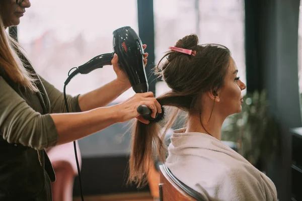 Blondynka Fryzjer Szczotkowanie Swoich Klientów Proste Brązowe Włosy Podczas Gdy — Zdjęcie stockowe