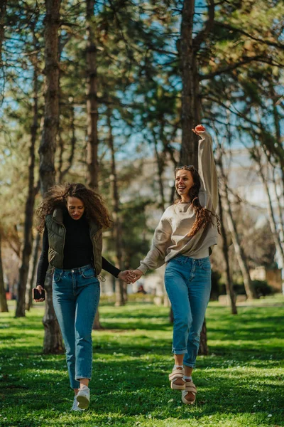 Δύο Χαρούμενα Χαμογελαστά Πανέμορφα Κορίτσια Χορεύουν Ενώ Περπατούν Στο Πάρκο — Φωτογραφία Αρχείου
