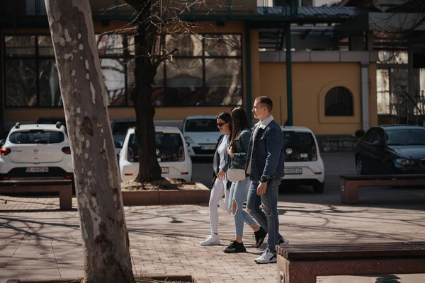 駐車場の隣の市内中心部を歩いている3人の幸せな友人 — ストック写真