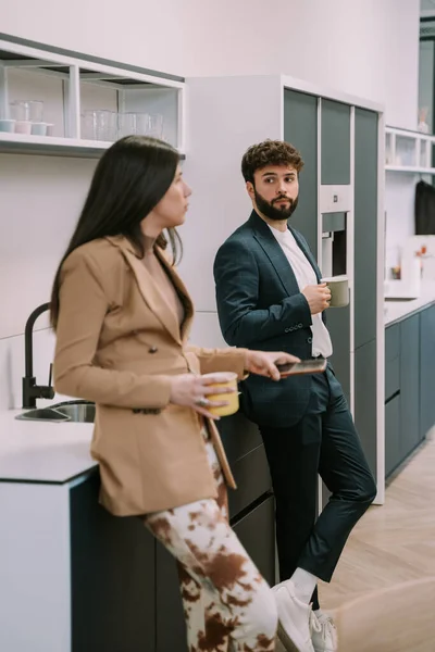 同僚とお金を話しながらコーヒーを持っている豪華なブルネットの実業家 — ストック写真