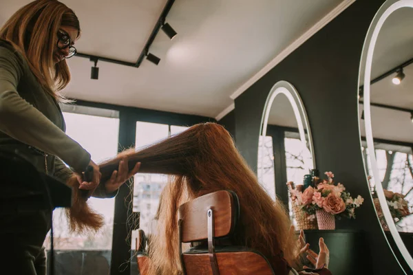Saç Kuaförünün Müşterilerini Fırçaladığı Kırmızı Uzun Dalgalı Saçları Kapatın — Stok fotoğraf