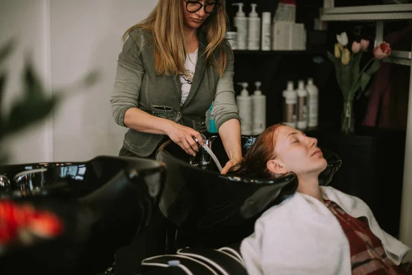 Sarı Saçlı Kuaför Müşterilerini Lavaboda Kızıl Saçlarıyla Yıkıyor — Stok fotoğraf