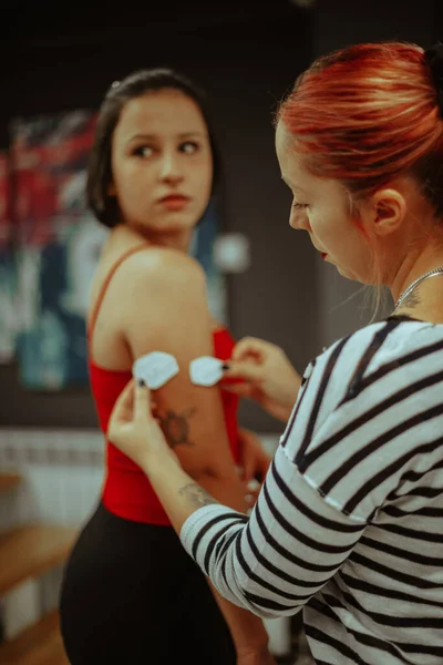 Dövmeci Kızıl Saçlı Müvekkilindeki Dövme Tasarımının Iki Boyutuna Bakıyor — Stok fotoğraf