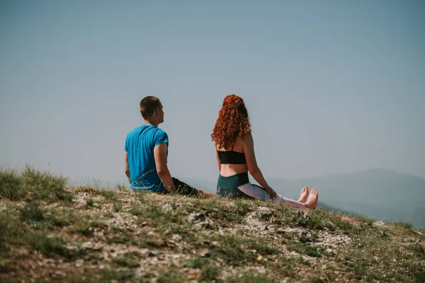 山の頂上に座っているヨガのカップルの終わり — ストック写真