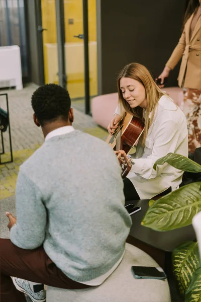Lovely Blonde Girl Playing Guitar While Her Black Male Colleague — Stok fotoğraf