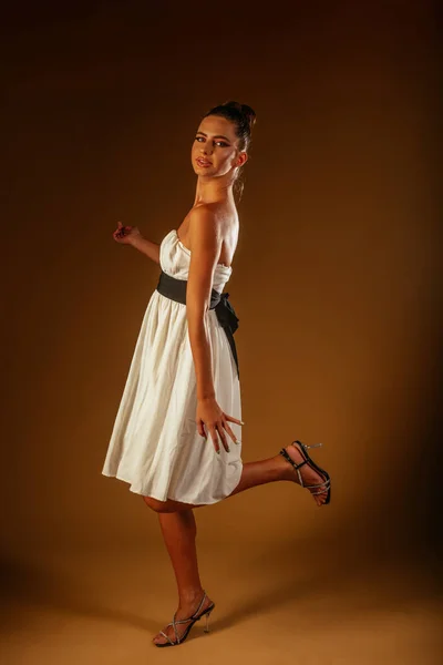 Una Hermosa Chica Traje Blanco Posando Estudio Sobre Fondo Marrón — Foto de Stock