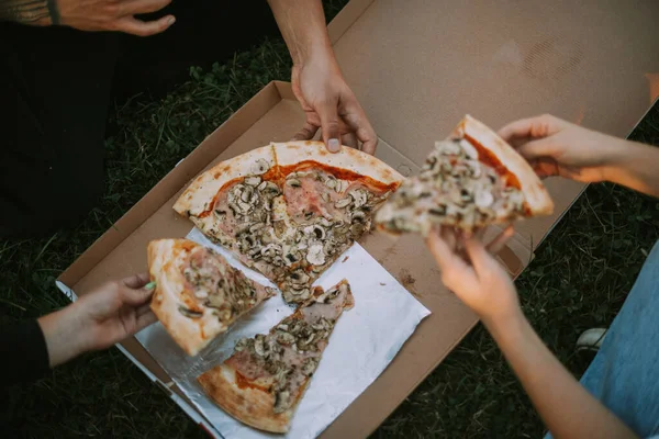 Três Amigos Tirando Uma Fatia Pizza Caixa Enquanto Sentados — Fotografia de Stock