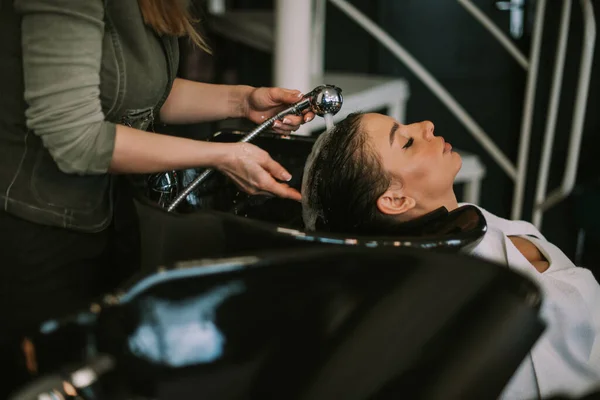 美发师在美发店洗发池旁的洗发水女孩的近照 — 图库照片