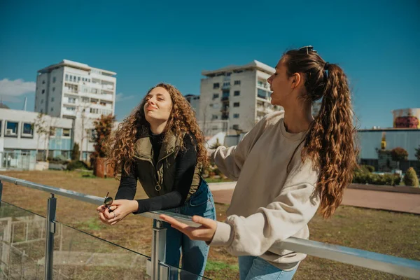 美丽的少女们在公园里享受着阳光灿烂的天气 卷发女孩面对朋友的意见 — 图库照片