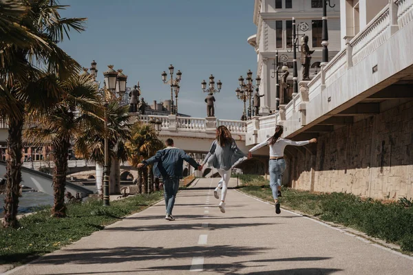 Tre Amici Che Tengono Mano Mentre Saltano Parco Della Città — Foto Stock