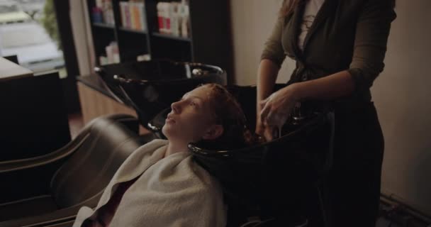 Frontansicht Des Friseurs Der Einem Ingwermädchen Friseurstudio Die Haare Wäscht — Stockvideo