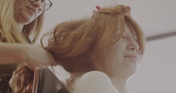 소녀의 곱슬머리를 만드는 프로페셔널 스타일 미용실 비디오 — 비디오