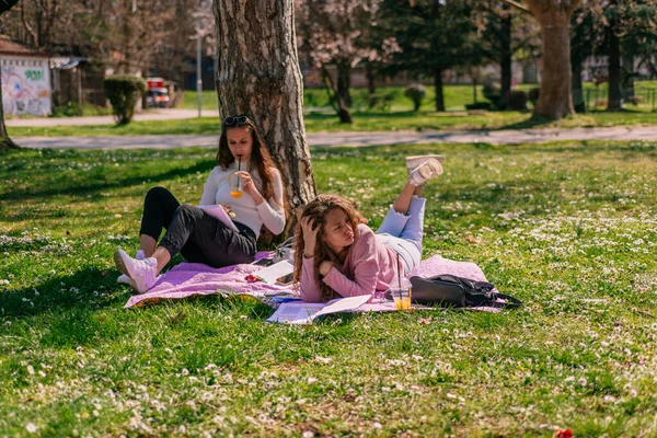 Μαθήτριες Διασκεδάζουν Στο Πάρκο Μια Ηλιόλουστη Μέρα Διαβάζοντας Μαζί — Φωτογραφία Αρχείου