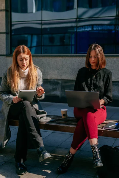 Όμορφες Επιχειρηματίες Κάθονται Ένα Παγκάκι Έξω Μια Ηλιόλουστη Μέρα Και — Φωτογραφία Αρχείου