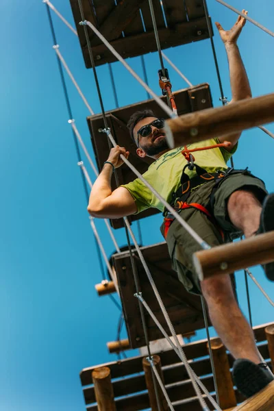 在冒险公园 一个运动员在高高的空中穿越木板 — 图库照片
