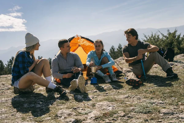 Quatro Caminhantes Relaxando Enquanto Sentados Fazendo Café Topo Montanha — Fotografia de Stock