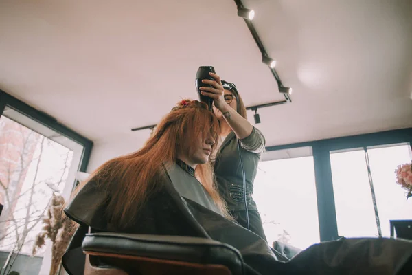 Блондинка Перукар Висушує Своїх Клієнтів Червоне Волосся Перукарні Стоячи — стокове фото
