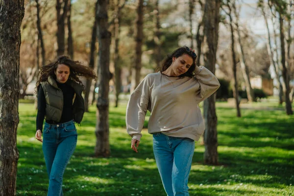 Dvě Dívky Procházející Parku Bruneta Dívka Dotýká Její Vlasy Kudrnaté — Stock fotografie
