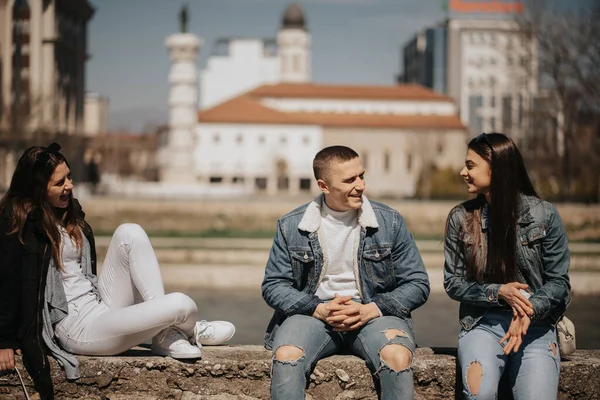 Three Friends Hanging Out Smiling While Sitting Next River City — Stock Photo, Image