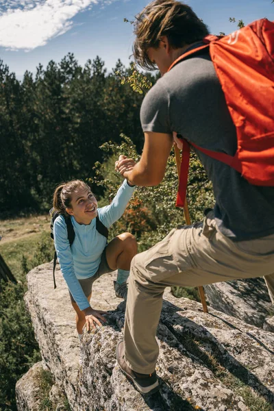 Przystojny Mężczyzna Pomaga Swojej Dziewczynie Wspiąć Się Skałę Górach — Zdjęcie stockowe