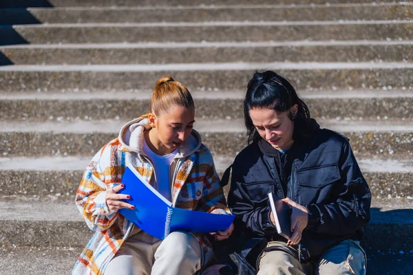 Una Estudiante Rubia Está Leyendo Solución Cuaderno Mientras Estudiante Morena —  Fotos de Stock