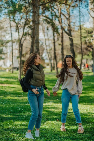 Полнометражный Снимок Двух Великолепных Девушек Веселых Бесед Улыбок Тусующихся Парке — стоковое фото