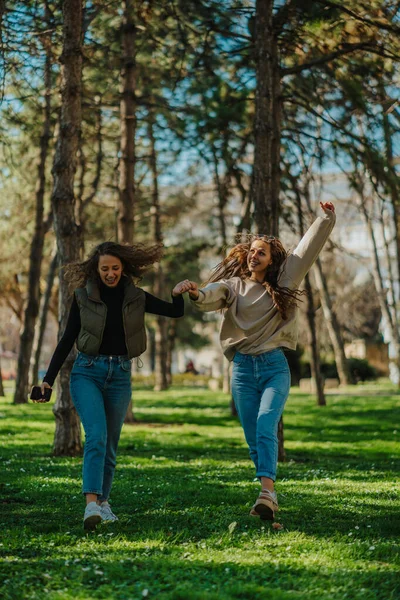 Φωτογραφία Δύο Όμορφα Κορίτσια Χορεύουν Ενώ Περπατούν Κρατάνε Χέρια Τους — Φωτογραφία Αρχείου