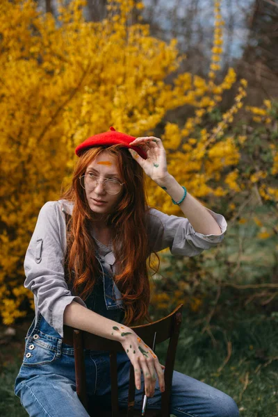 Beautiful Ginger Painter Girl Taking Her Red Beret While Sitting — Stock Photo, Image