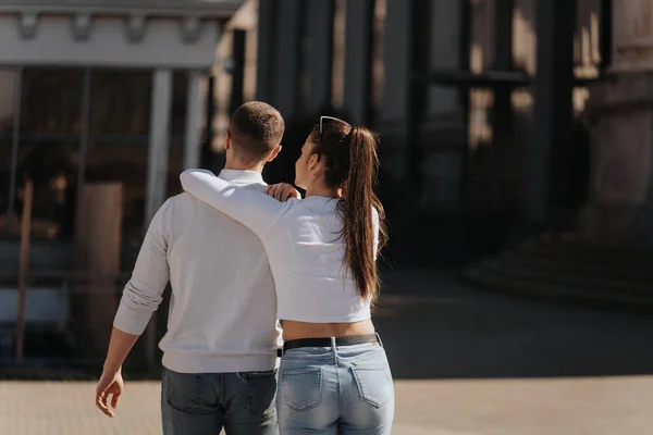一个漂亮的黑发女孩站在城里拥抱她的男朋友 — 图库照片