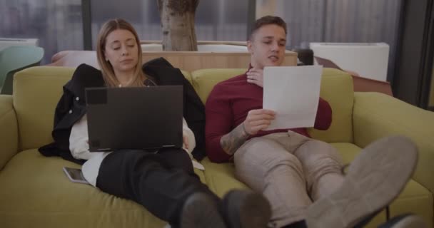 Genç Erkek Bayan Meslektaşlar Ofisteki Rahat Koltukta Çalışırken Dinlenmeye Başlıyorlar — Stok video