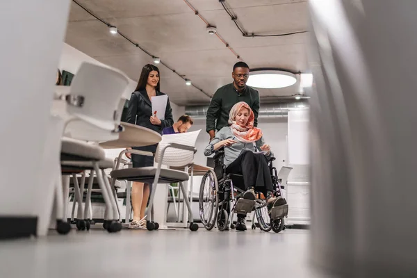 Engelli Meslektaşını Ofiste Tekerlekli Sandalyeye Itiyor — Stok fotoğraf