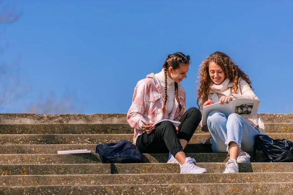 建物の階段に座って一緒に勉強している2人の若い女の子の写真 — ストック写真
