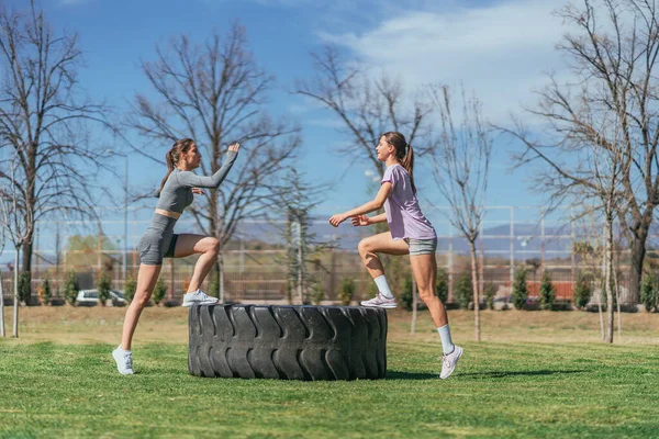 Две Спортивные Девушки Смотрят Друг Друга Время Тренировки Шине Грузовика — стоковое фото