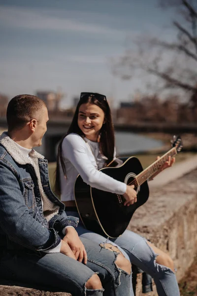 Otururken Erkek Arkadaşlarına Gitar Çalan Güzel Esmer Kızı Yakından Çek — Stok fotoğraf