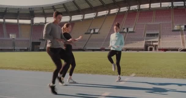 三个人伸着腿准备在体育场跑步 — 图库视频影像