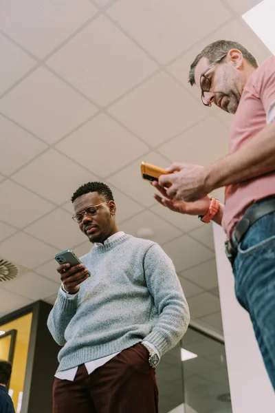 Multiraciale Volwassen Kantoormedewerkers Die Naar Hun Telefoon Kijken Bij Het — Stockfoto